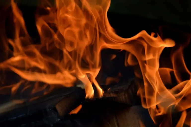 Flames and glowing embers illustrating heat application for finish curing processes.
