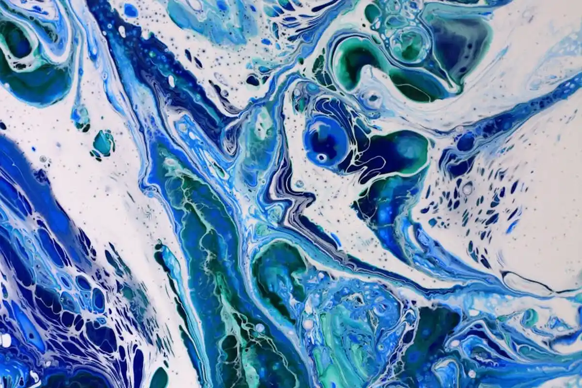 Close-up of an abstract blue and teal paint swirl, suggesting the natural, resin-based texture associated with shellac.