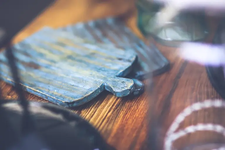 Blue-painted wooden cutting board on a warm wooden countertop with soft-focus foreground