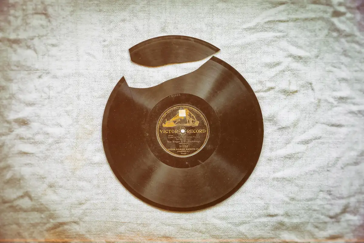A cracked vintage shellac 78 rpm record on a textured light-colored cloth