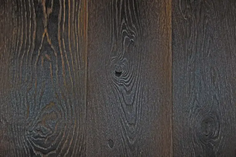 Close-up of dark wood planks with pronounced grain and water-stain rings.
