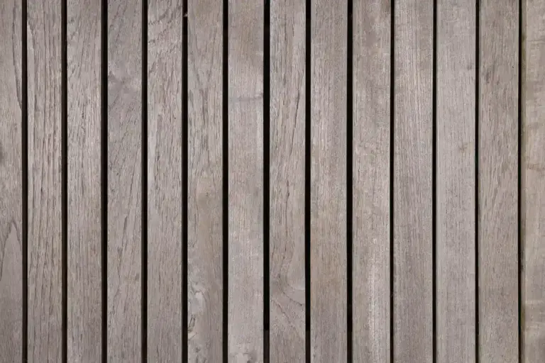 Close-up of vertical wooden deck boards with visible grain and narrow gaps.