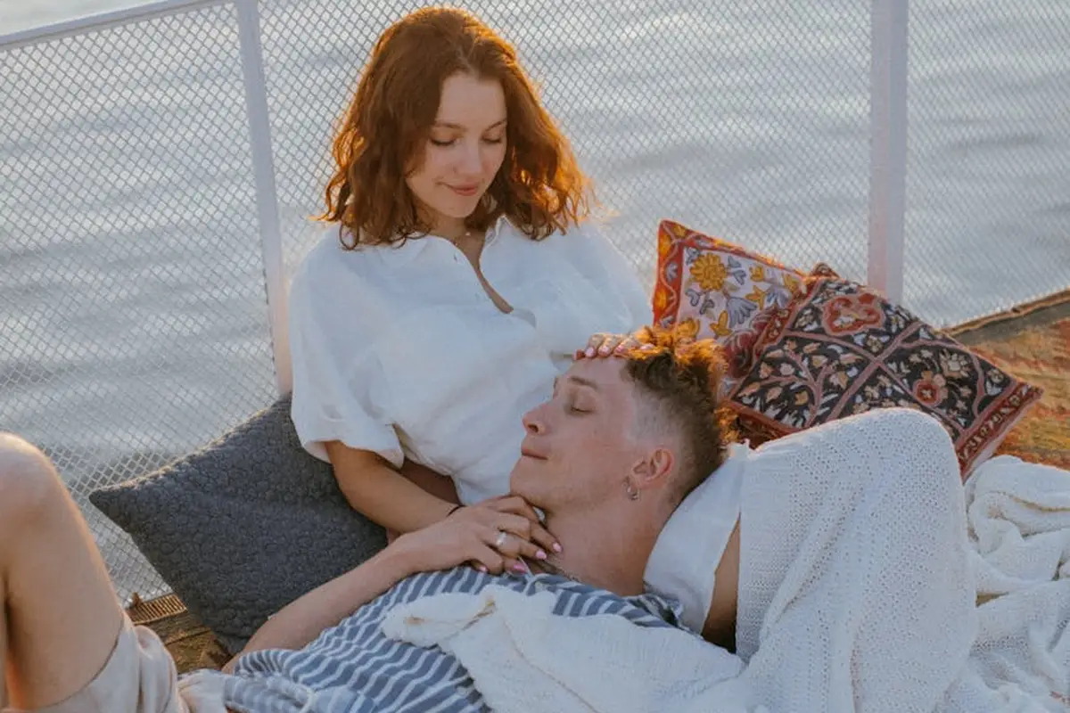 A couple relaxing on a wooden deck by the water