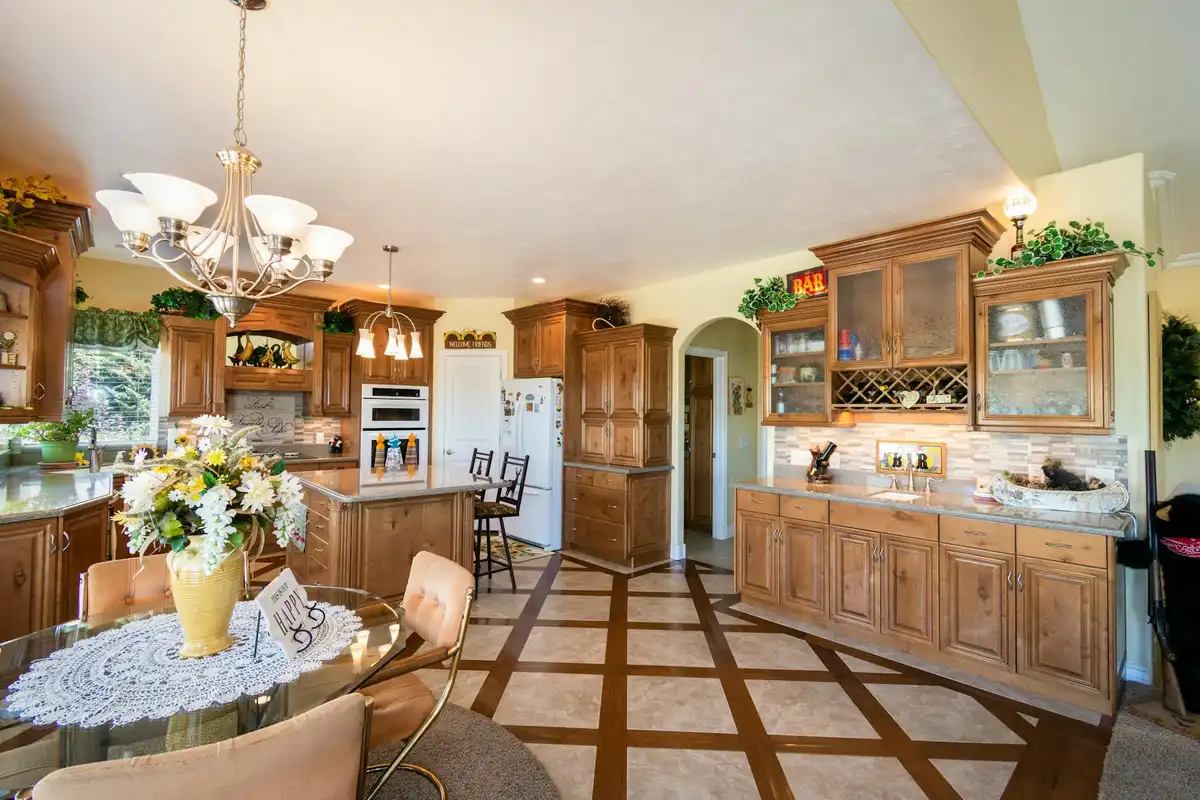 Bright kitchen with natural wood cabinets, tile floor, and an island, showcasing a wood finish in a residential space.