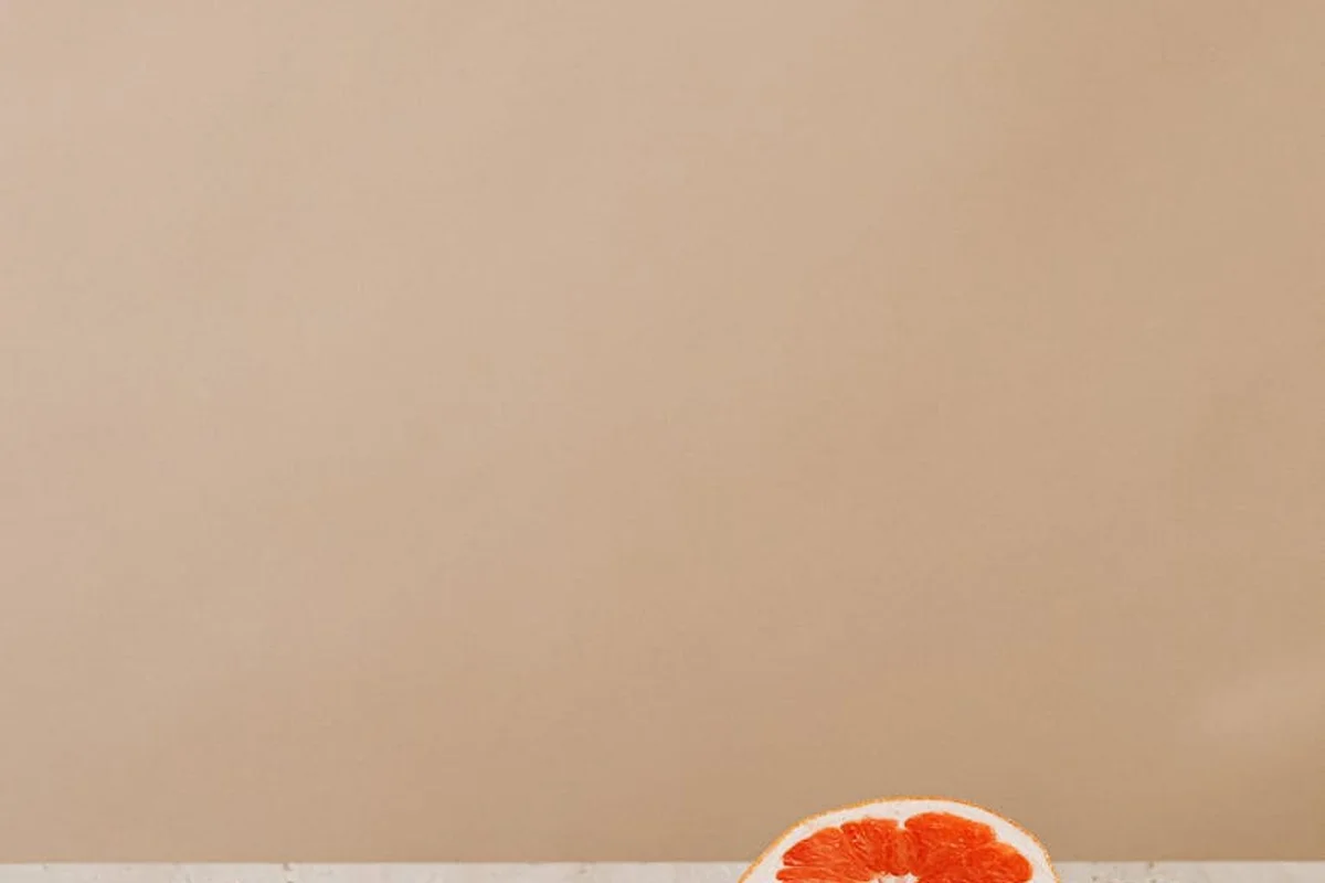 Partial orange slice on a plain beige surface
