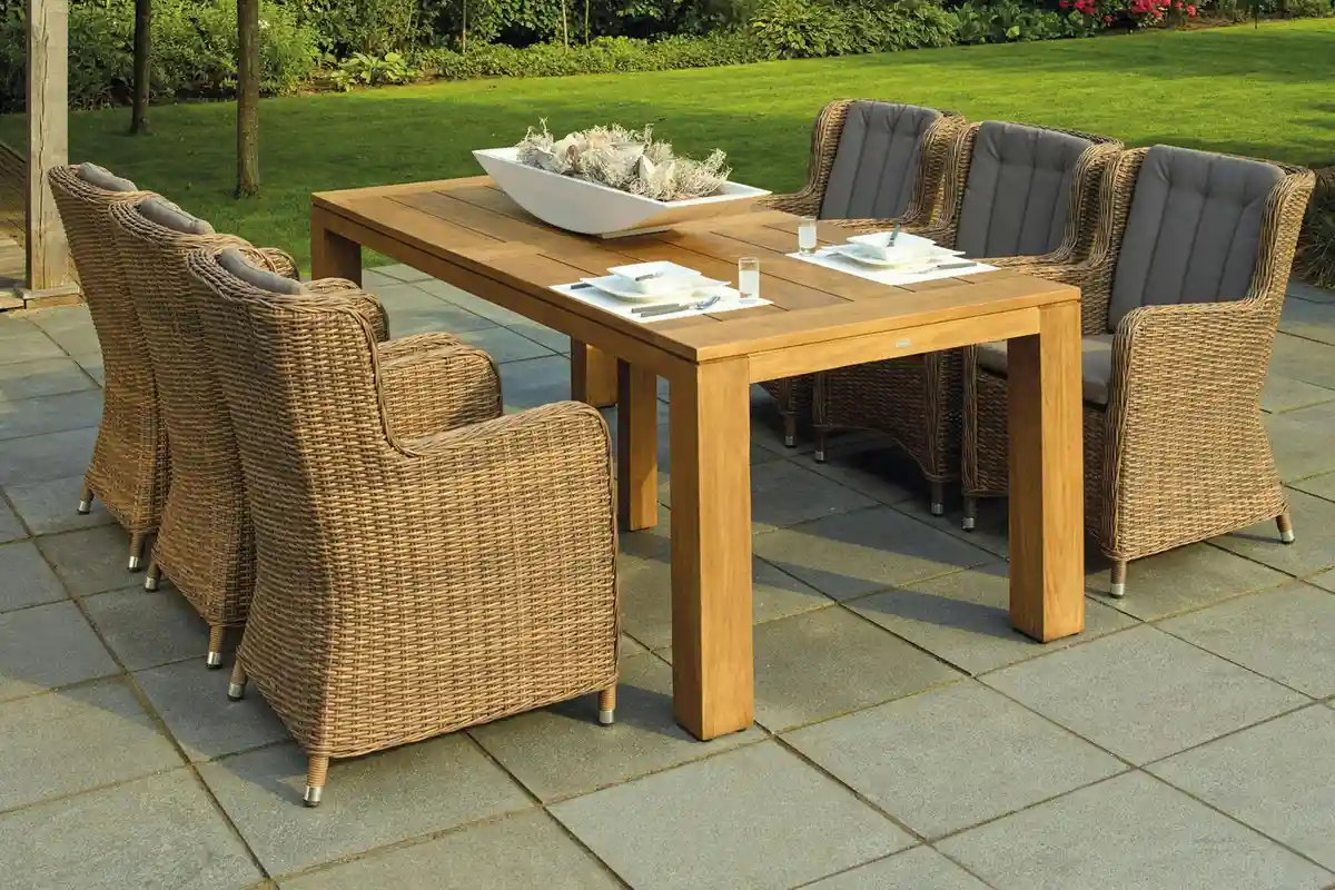 Outdoor dining table with wicker chairs on a tiled patio