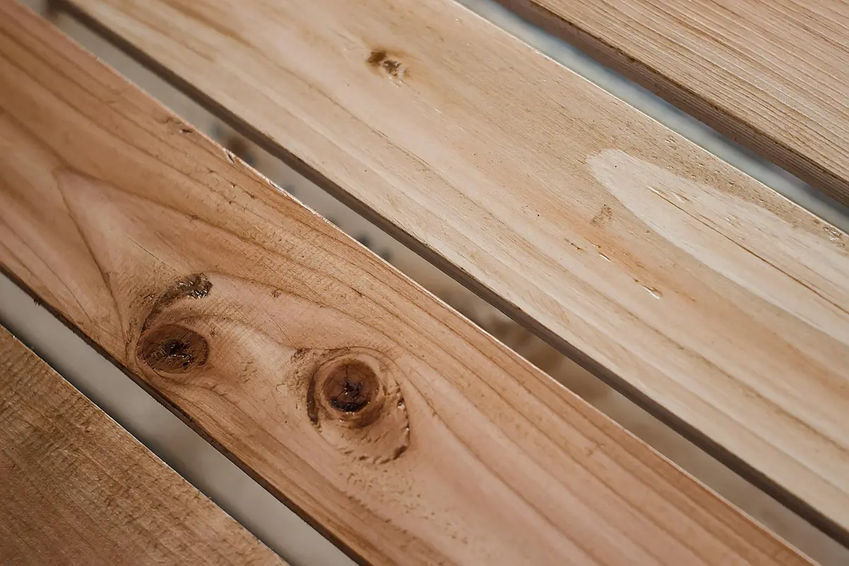 Close-up of pine boards with visible knots and grain, prepared for painting