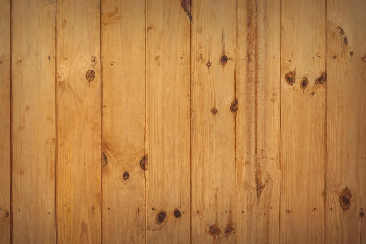 Vertical pine boards with knots and warm grain patterns.