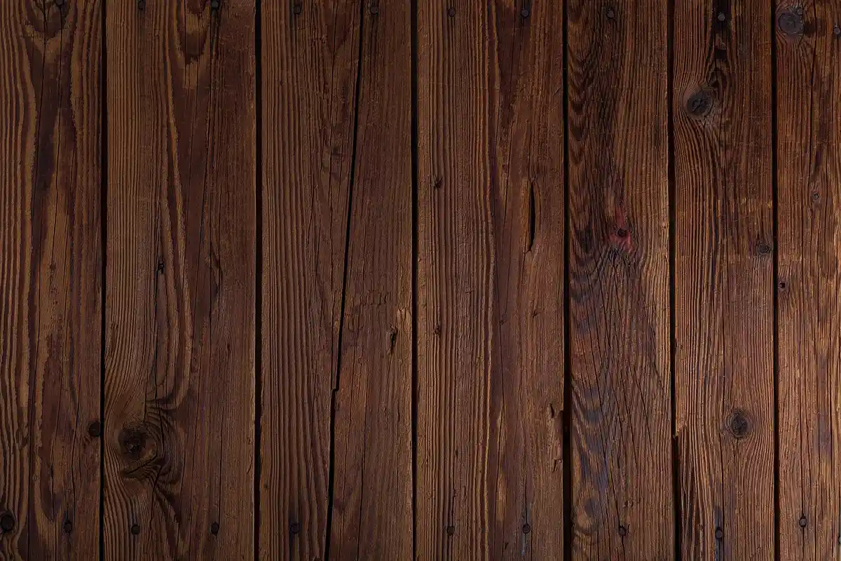 Close-up of dark-stained wooden deck boards with visible grain and texture.