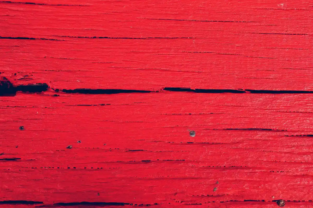 Close-up of a red-painted wooden surface with visible grain lines