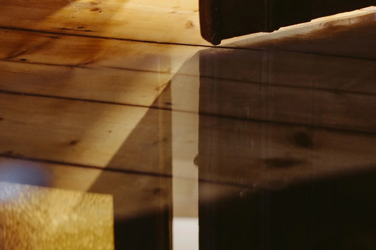 Close-up of a wooden joint with a thin wedge inserted to tighten the fit between boards