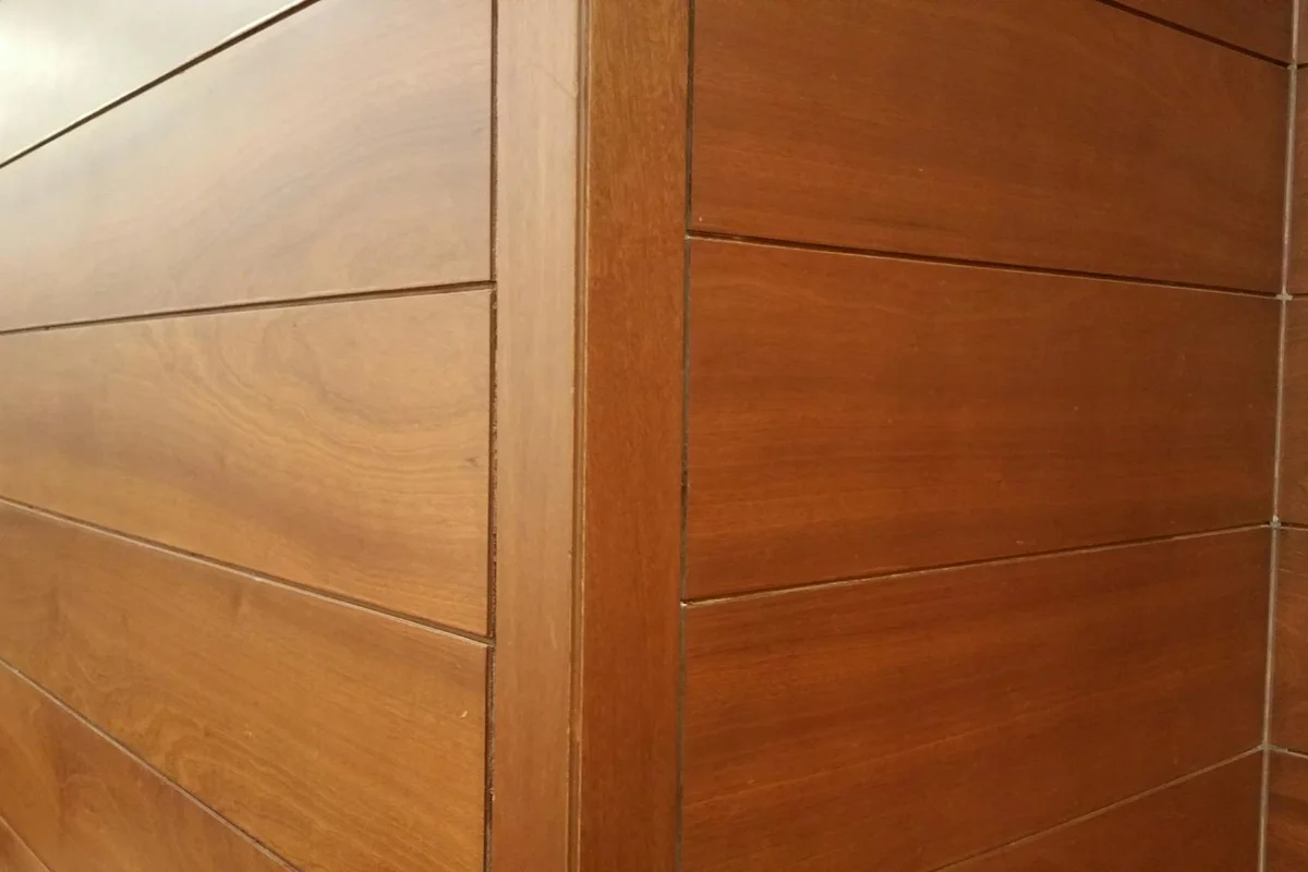 Close-up view of warm-toned wooden wall panels with visible grain and tight joints.