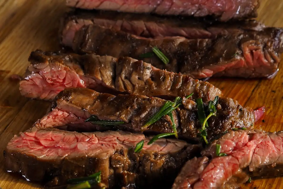 Sliced steak on a wooden cutting board