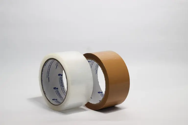 Two adhesive tape rolls, white and brown, placed side by side on a white backdrop, illustrating controlled adhesive application and the importance of proper gap-filling