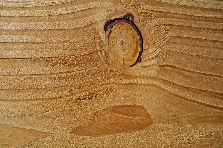 Close-up of a wooden surface showing distinct grain patterns and a knot