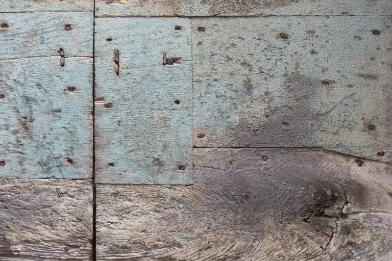 Weathered wooden planks with faded blue paint and visible grain