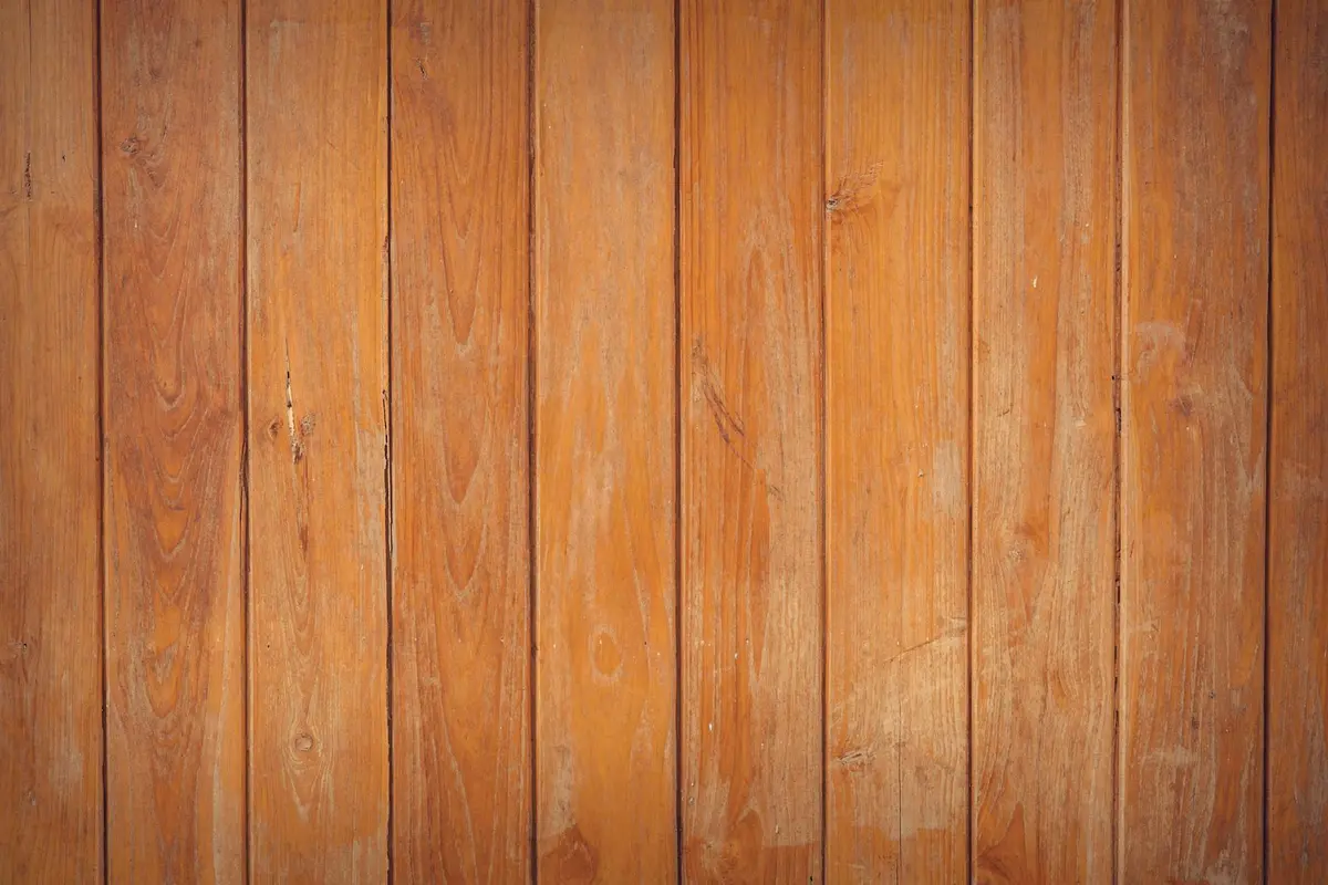 Close-up of vertical wooden boards with warm orange-brown tones lining a workshop wall