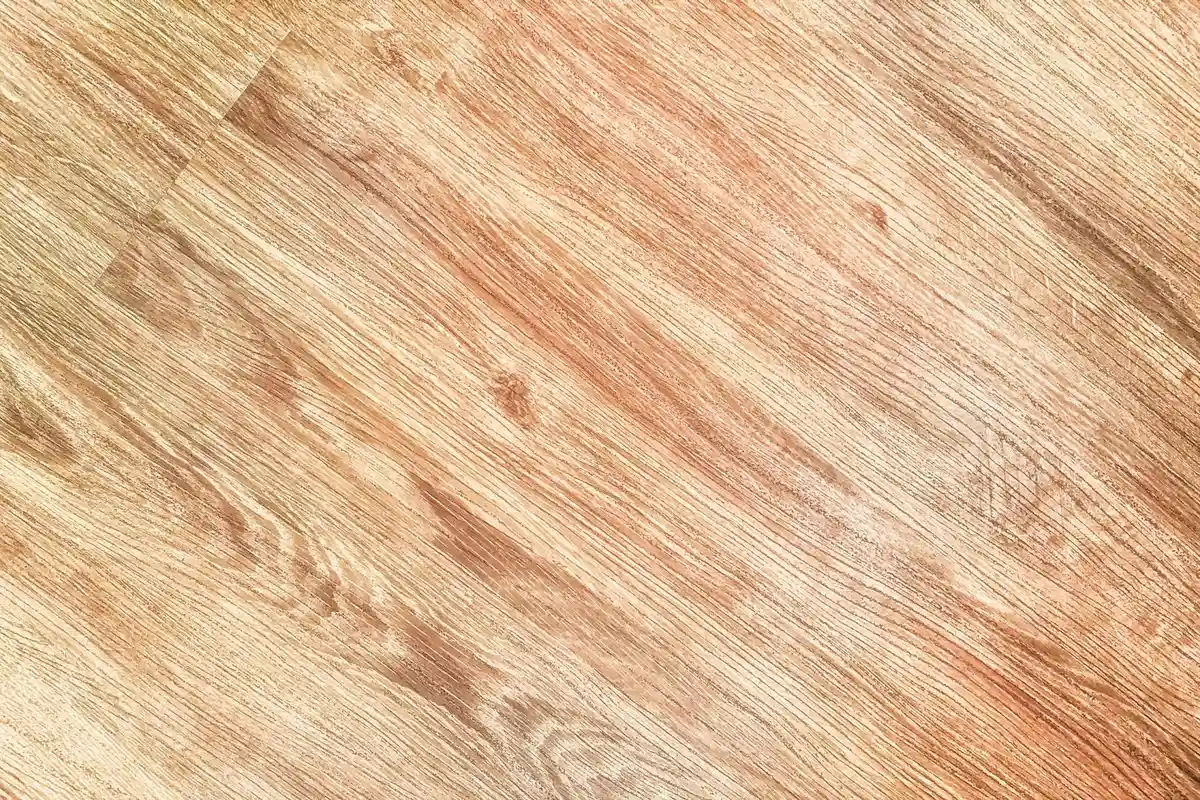 Close-up of a wooden table surface with visible grain and worn finish, suggesting abrasion as a final option for stain removal
