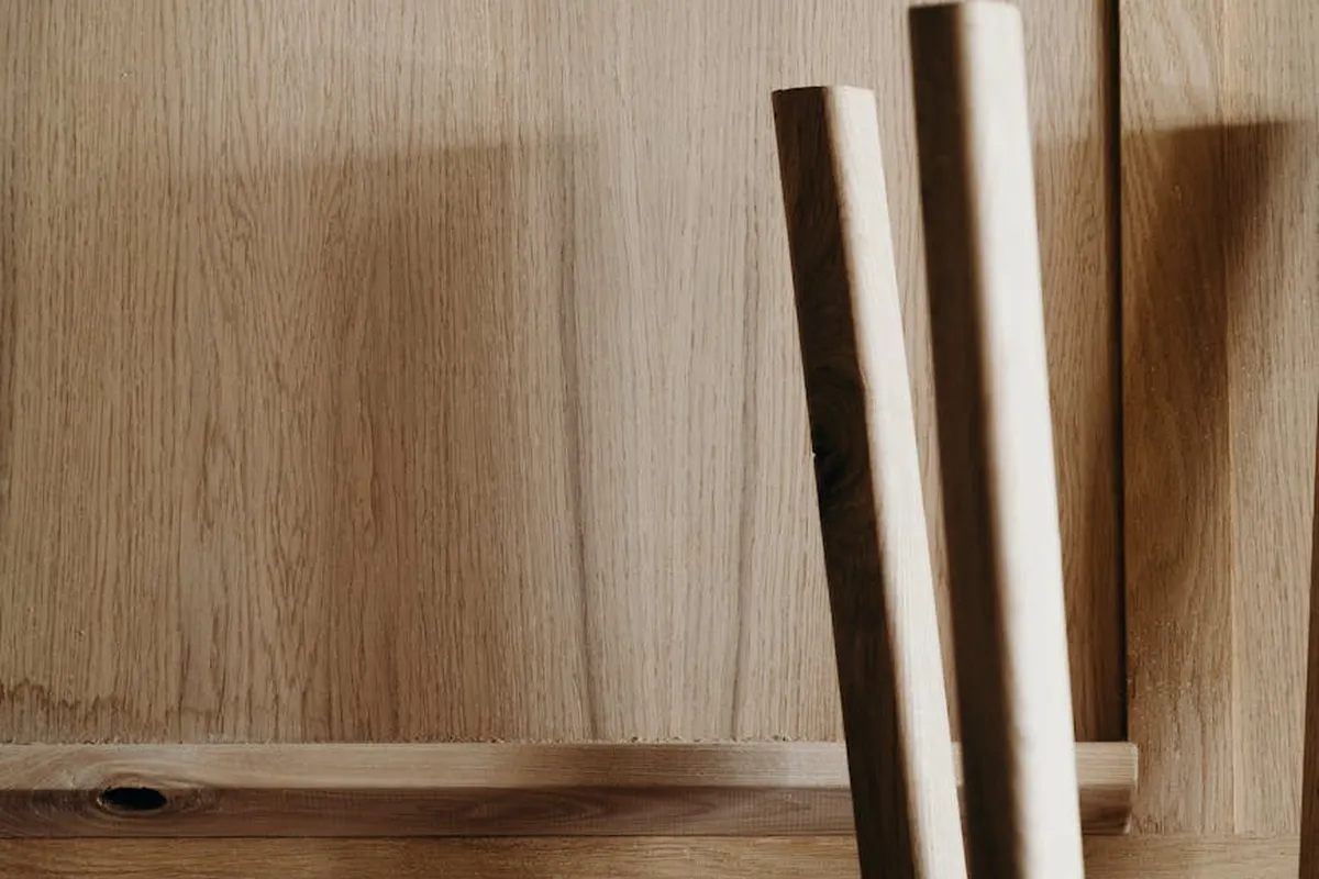 Two wooden legs leaning against a wooden panel, illustrating prep work on wood surfaces