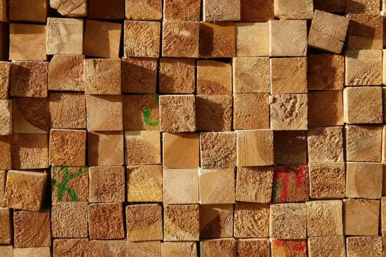 Close-up of stacked square-cut lumber blocks showing wood grain and cross-sections.