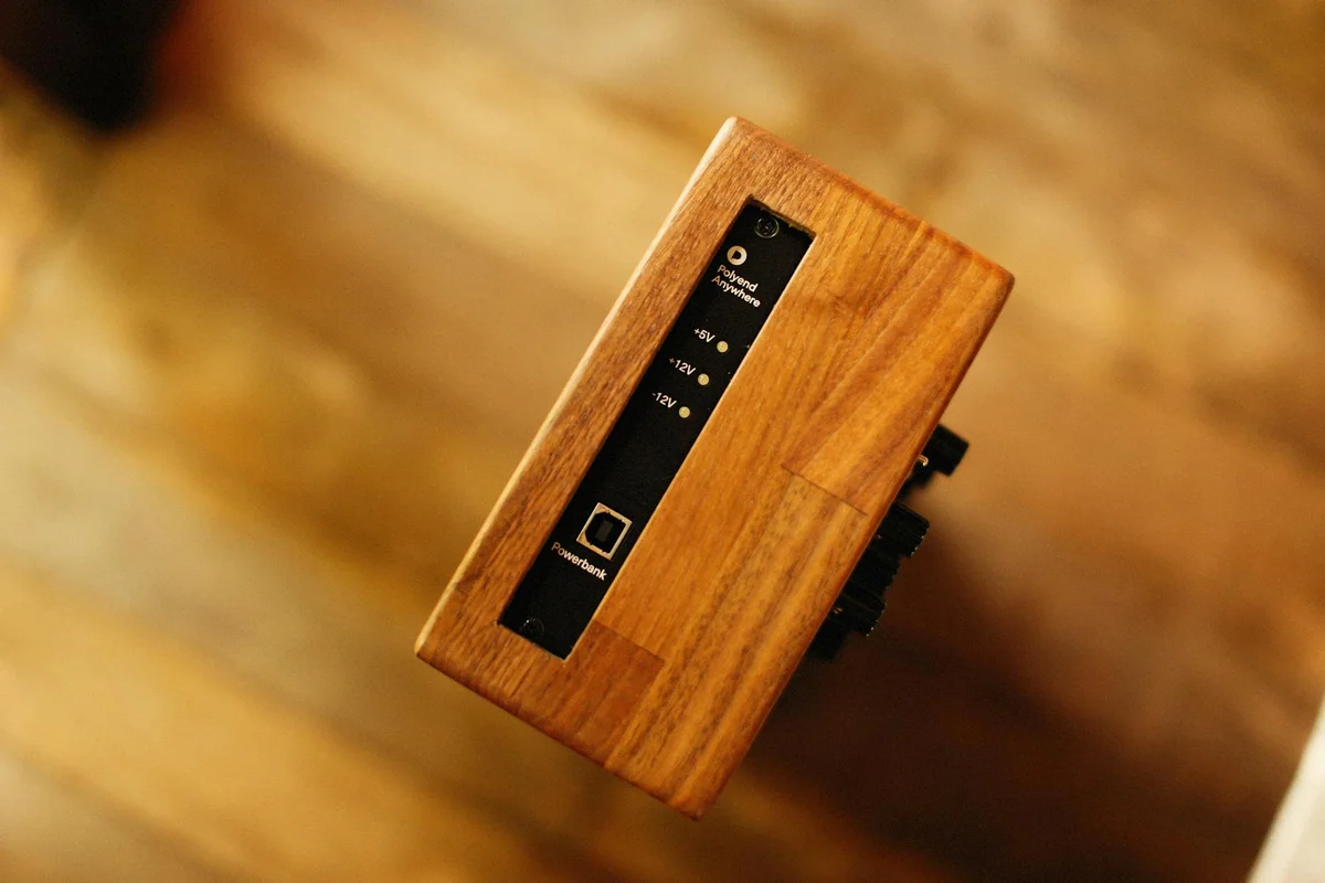 Close-up of a wooden block with a black vertical control panel, a component of a finish-testing setup