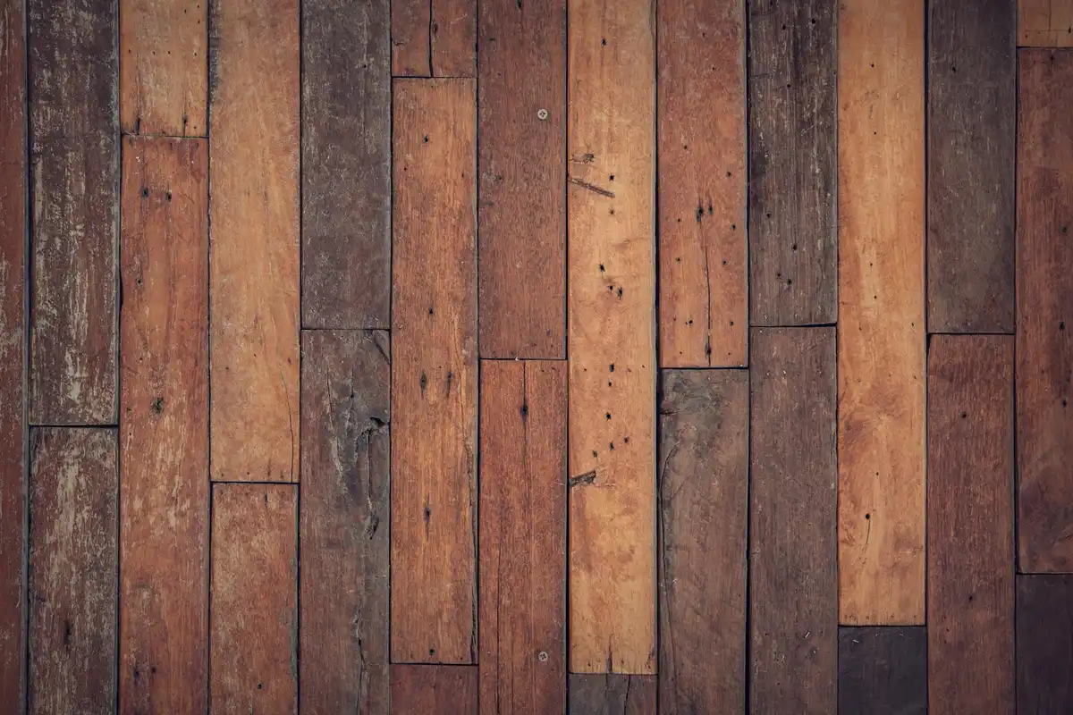 Close-up of wooden floor planks in varying brown tones with a rustic finish.