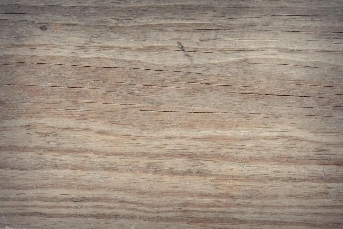Close-up of light brown wooden floorboards with visible grain and texture.