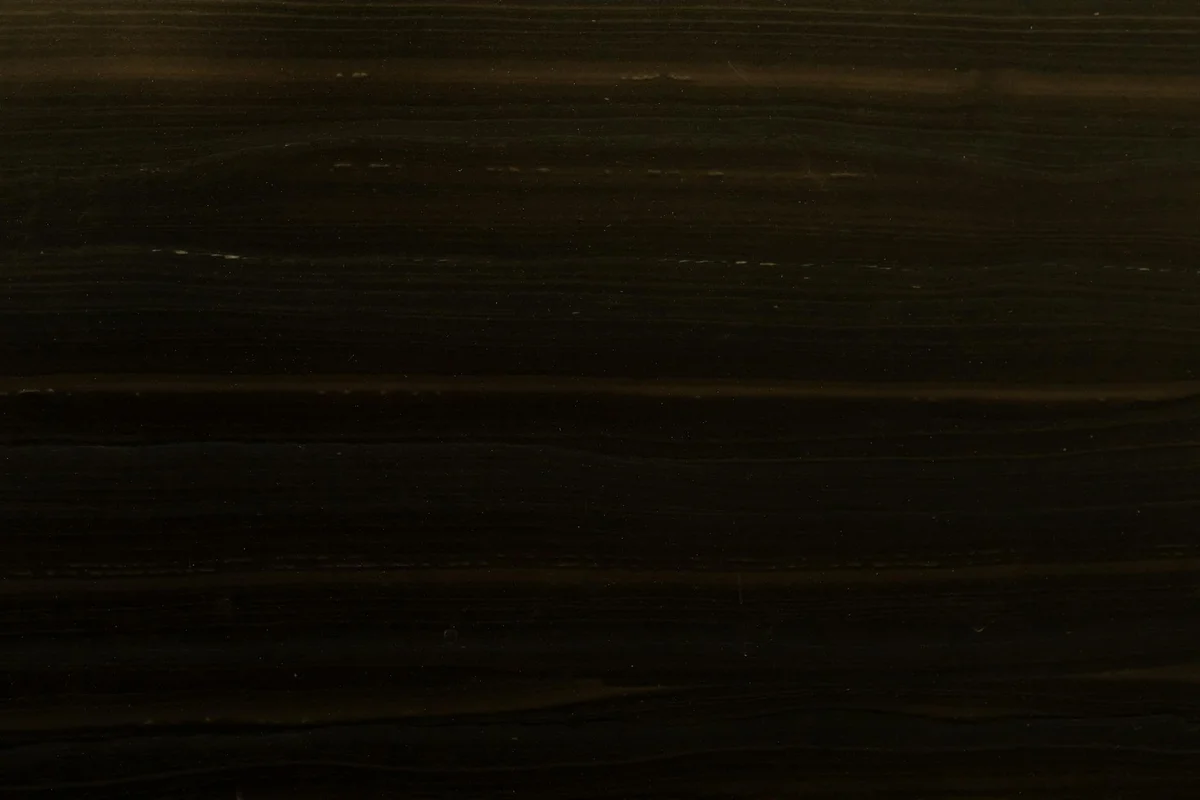 Dark wood grain texture with subtle horizontal bands across a polished surface.