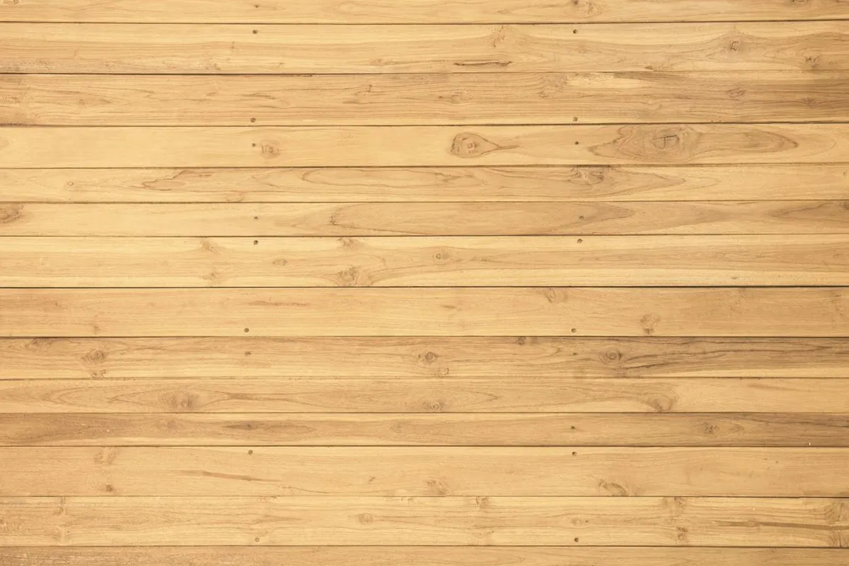 Close-up of light-colored wooden planks arranged horizontally, highlighting grain patterns and small knots.