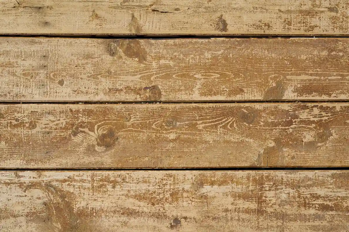 Weathered wooden planks with a worn, light-brown finish.