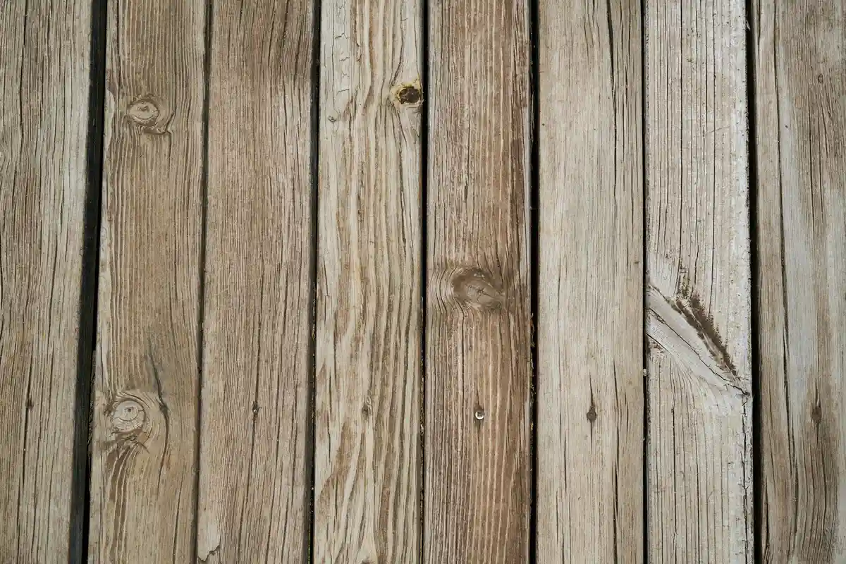 Close-up of weathered wooden planks with visible grain and knots, representing common softwood lumber