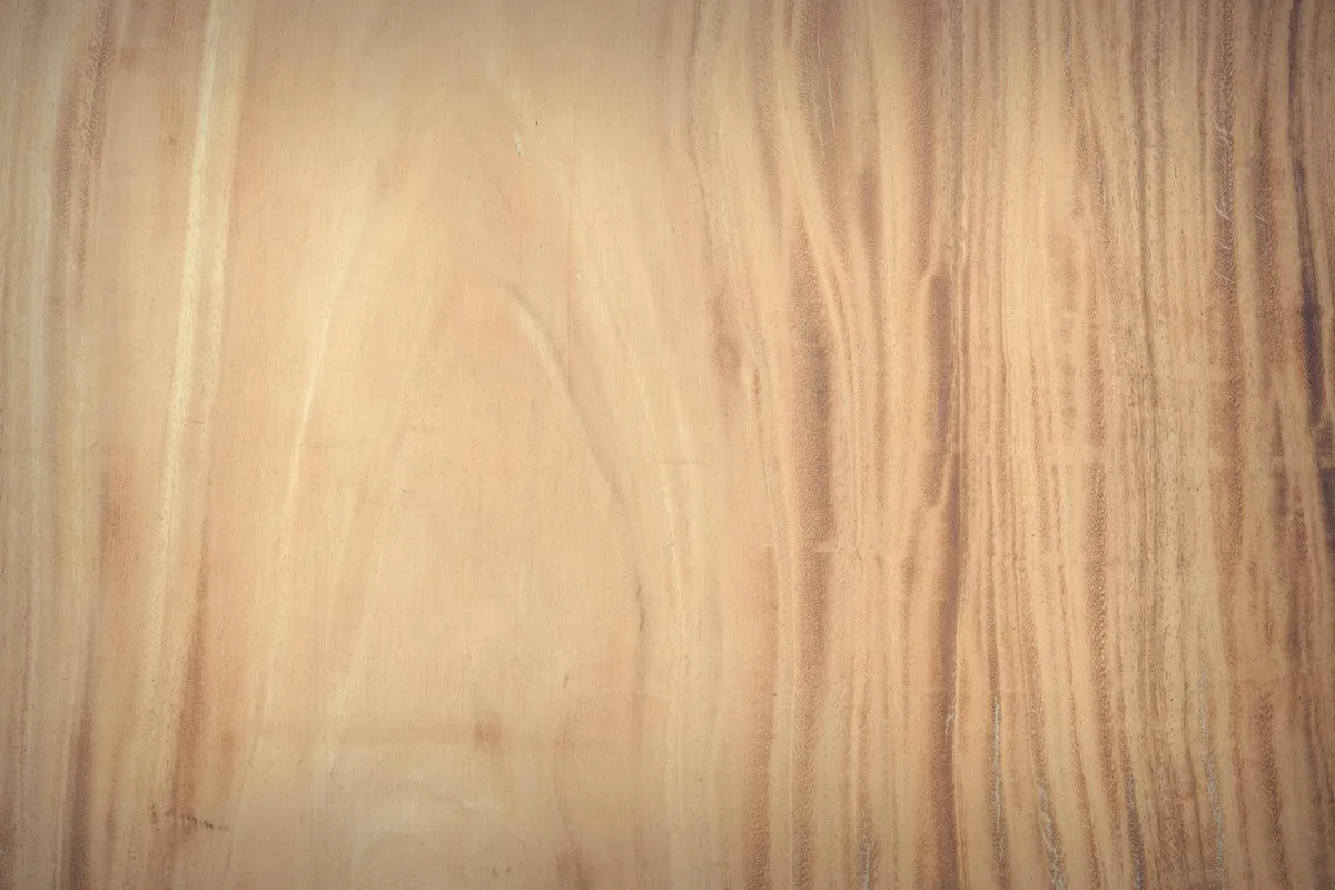 Close-up of a light wood surface with vertical grain patterns.