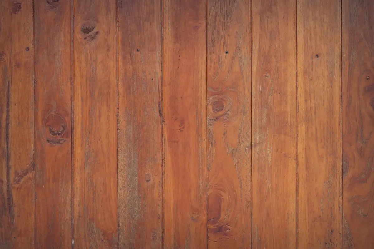 Close-up view of warm-toned wooden decking planks with visible grain and knots.