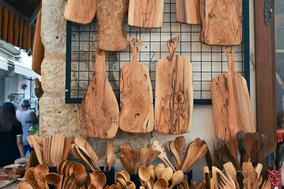 Display of wooden spoons and cutting boards in a market stall, showcasing natural wood tones and grain.